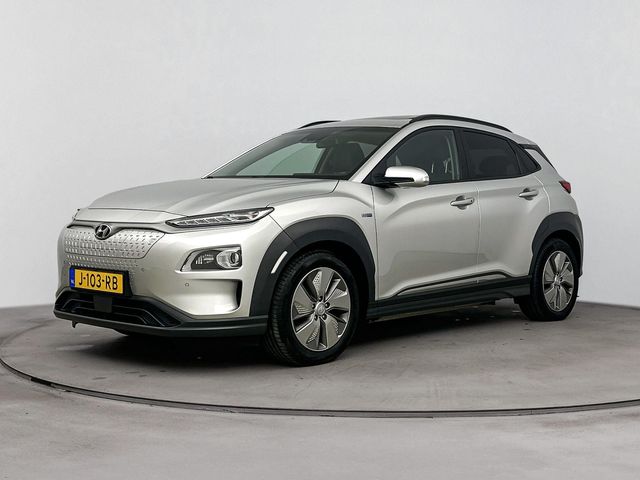 Hyundai Kona EV PREMIUM 64 kWh | 3- FASE | NAVI | CLIMA | CRUISE | CAMERA | HUD | LEDER | SCHUIFDAK | STUUR- & STOELVERWARMING | WARMTEPOMP | PRIVACY GLASS | WLTP 481 KM! |