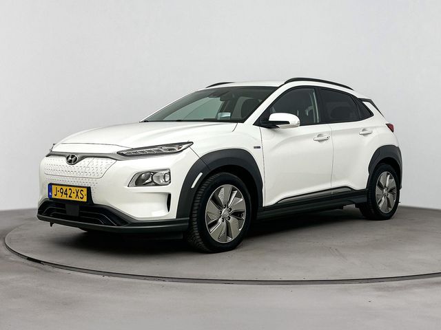 Hyundai Kona EV FASHION 64 kWh | SoH 95,2 %! | TREKHAAK | DODEHOEK DETECTIE | PDC | 3 FASEN | WARMTEPOMP | CAMERA | CLIMA | CRUISE | NAVI | STOELVERWARMING | STUURVERWARMING | PRIVACY GLASS |